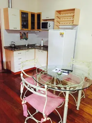 a glass table and two chairs in a kitchen at Cabañas y Lofts El Portal in Villa General Belgrano