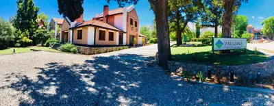 a house with a sign in front of a driveway at Paradiso Hotel in Merlo