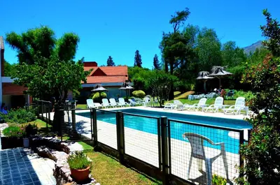 a swimming pool with chairs and a fence around it at Paradiso Hotel in Merlo