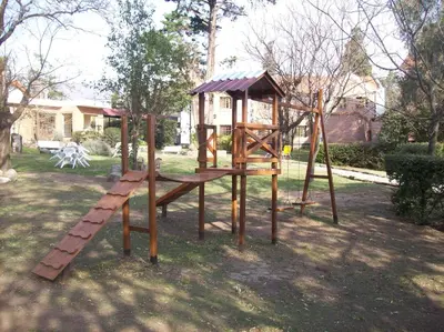 a wooden playground with a slide and a ladder at Paradiso Hotel in Merlo