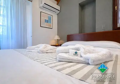 a bedroom with two white towels on a bed at Paradiso Hotel in Merlo