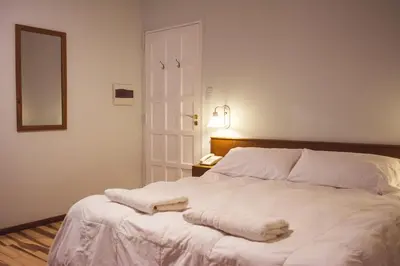 a bedroom with a white bed with two towels on it at Solares Hotel & Spa in Alta Gracia