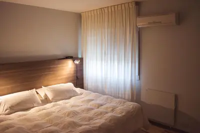 a bedroom with a white bed with a window at Solares Hotel & Spa in Alta Gracia