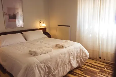 a bedroom with a white bed with towels on it at Solares Hotel & Spa in Alta Gracia