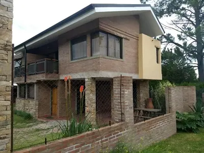 a brick house with a fence in front of it at Los algarrobos in Villa Carlos Paz