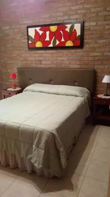 a bedroom with a bed and a painting on the wall at Los algarrobos in Villa Carlos Paz