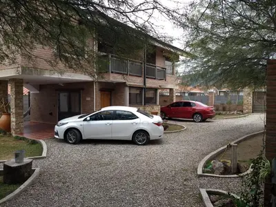 a white car parked in front of a building at Los algarrobos in Villa Carlos Paz