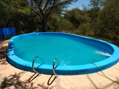 a large blue swimming pool with glasses in it at Cabaña Tío Miguel in Los Molles