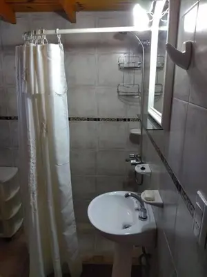 a bathroom with a sink and a shower curtain at Cabaña Tío Miguel in Los Molles