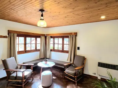 a living room with a table and chairs at Hotel La Cumbrecita in La Cumbrecita