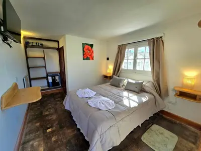 a bedroom with a bed with towels on it at Hotel La Cumbrecita in La Cumbrecita