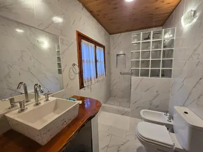 a white bathroom with a sink and a toilet at Hotel La Cumbrecita in La Cumbrecita