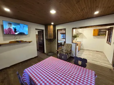a room with a table and a tv on the wall at Hotel La Cumbrecita in La Cumbrecita