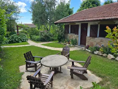 a table and chairs in a yard with a patio at Hotel La Cumbrecita in La Cumbrecita