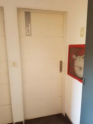 a white garage door with a red painting on it at Edificio Pampa - Departamento Nueva Córdoba in Cordoba