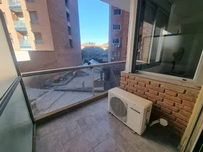 a room with a balcony with a microwave and a window at Edificio Pampa - Departamento Nueva Córdoba in Cordoba