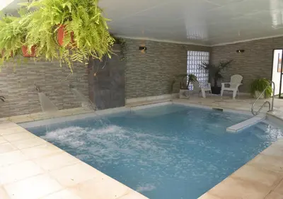 a large swimming pool with water in a room at Windmuhle Apart Hotel & Spa in Villa General Belgrano