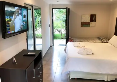 a bedroom with a bed and a flat screen tv at Windmuhle Apart Hotel & Spa in Villa General Belgrano