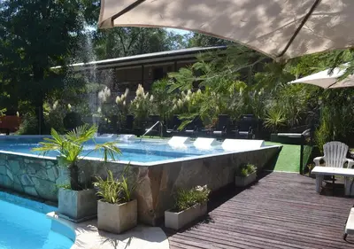 a swimming pool with a fountain in a yard at Windmuhle Apart Hotel & Spa in Villa General Belgrano