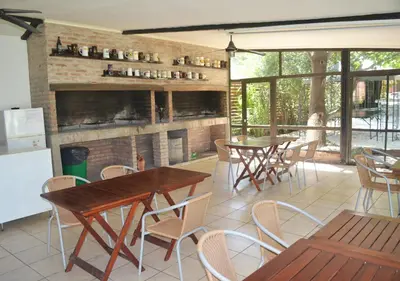 a restaurant with tables and chairs and a fireplace at Windmuhle Apart Hotel & Spa in Villa General Belgrano