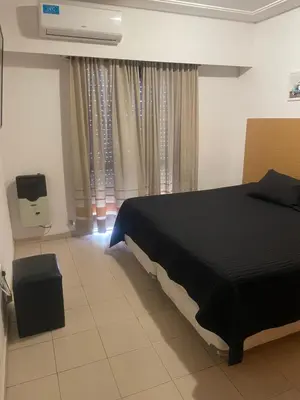 a bedroom with a black bed and a window at Alonso 540 Departamento in Río Cuarto