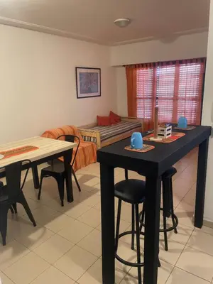 a living room with two tables and a bed at Alonso 540 Departamento in Río Cuarto