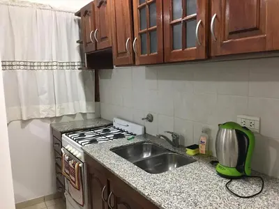 a kitchen with a sink and a stove top oven at Alonso 540 Departamento in Río Cuarto