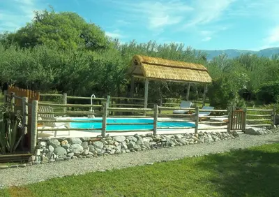 a swimming pool with a gazebo and a fence at Casitas Volver a Nacer in Carpintería