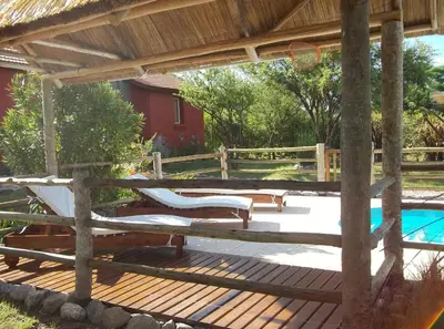 a wooden deck with a pergola and a pool at Casitas Volver a Nacer in Carpintería