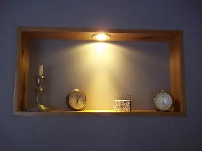 a mirror with two clocks on a shelf with a light at Casitas Volver a Nacer in Carpintería