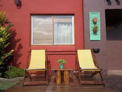 two chairs and a table in front of a building at Casitas Volver a Nacer in Carpintería