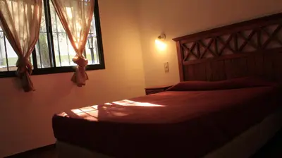a bedroom with a bed and two windows at La sacha sin fin in Merlo
