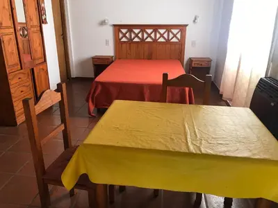 a bedroom with a bed and a table and chairs at La sacha sin fin in Merlo