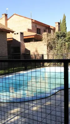 a tennis court in front of a house at La sacha sin fin in Merlo