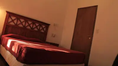 a bedroom with a bed and a wooden door at La sacha sin fin in Merlo