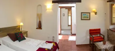 a hotel room with a bed and a chair at Las Dalias in Villa de Las Rosas