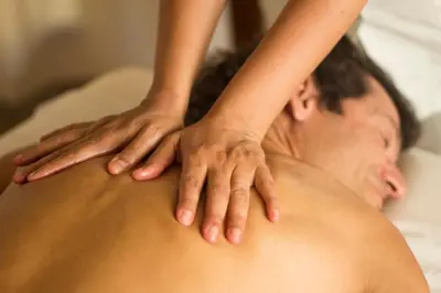 a man receiving a back massage from a woman at Las Dalias in Villa de Las Rosas