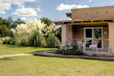 a woman sitting at a table outside of a house at Las Dalias in Villa de Las Rosas
