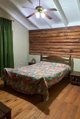 a bed in a room with a ceiling fan at El Camino Viejo Cabañas in Villa General Belgrano