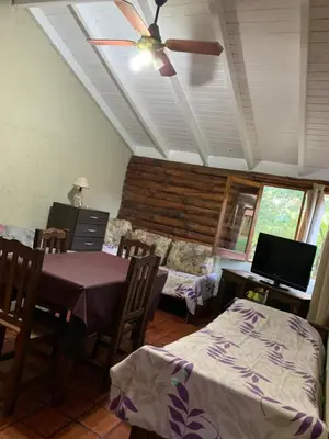 a dining room with a table and a ceiling fan at El Camino Viejo Cabañas in Villa General Belgrano
