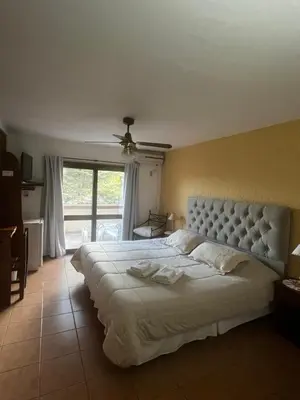 a bedroom with a large white bed and a window at Chalet Suisse Posada & SPA - Adults only in Villa General Belgrano
