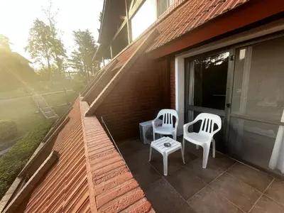 two chairs and a table on the porch of a house at Chalet Suisse Posada & SPA - Adults only in Villa General Belgrano