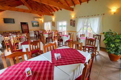 a restaurant with red and white tables and chairs at Apart Hotel Las Palmeras in Villa General Belgrano