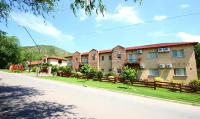 a building on the side of a road at Apart Hotel Las Palmeras in Villa General Belgrano