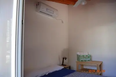 a bedroom with a bed and a air conditioner on the wall at Alquimia Cabañas in San Francisco del Monte de Oro