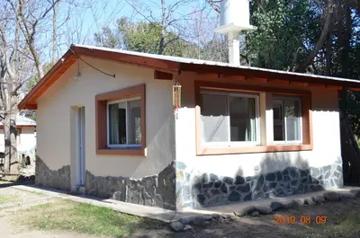 a small white house with two windows and a door at Alquimia Cabañas in San Francisco del Monte de Oro