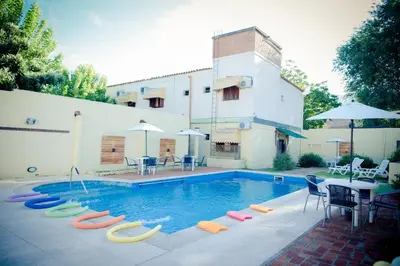a pool with colorful chairs and a table and a building at Casablanca Hotel & Spa in Santa Rosa de Calamuchita