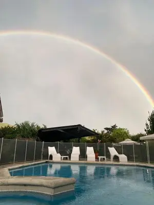 a rainbow over a swimming pool with a rainbow at Hotel Gloria in Santa Rosa de Calamuchita