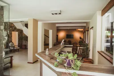 a kitchen and living room with a counter with plants at Hotel Gloria in Santa Rosa de Calamuchita