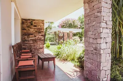 a patio with chairs and a table and a brick wall at Hotel Gloria in Santa Rosa de Calamuchita